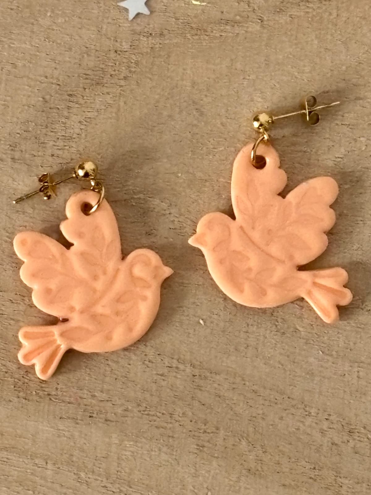 Boucles d’oreilles pendantes en forme d'oiseaux pêche pastel aux motifs végétaux gravés, sur bois