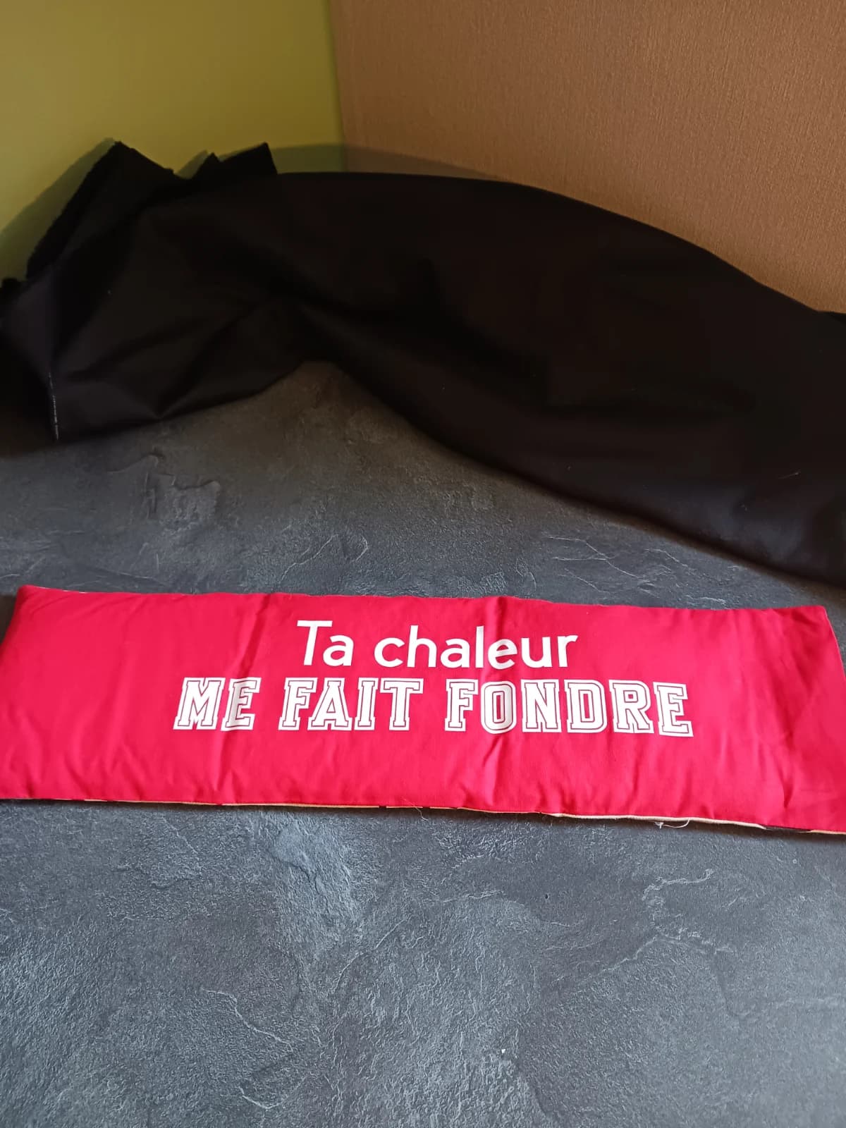 Bouillotte allongée en tissu rouge avec inscription blanche Ta chaleur ME FAIT FONDRE